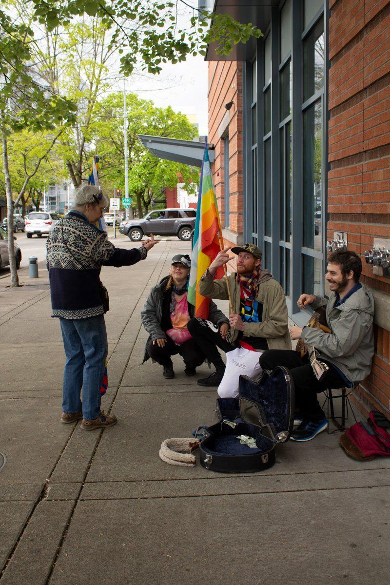 A group of protestors stands outside the Eugene Public Library. Even though the group doesn't have an official name, they have been meeting for one hour every Saturday for the past 20 years. Rain or shine, the group protests for peace.