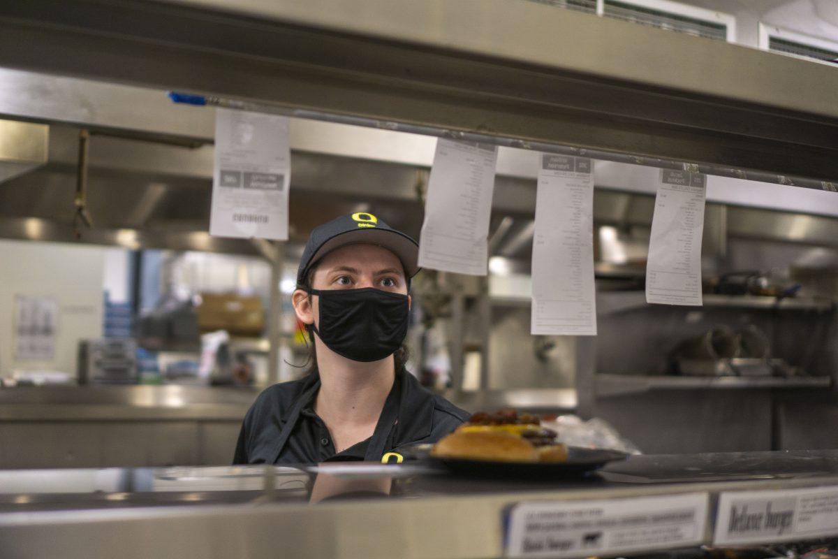 Rory Sweeney looks to her next ticket order during her shift at Hamilton Dining Hall&#8217;s Gastro Kitchen at the University of Oregon, where she works 25 hours a week. As a Student Service Leader, Sweeney not only prepares food orders but also makes sure other student workers get their breaks during shifts.