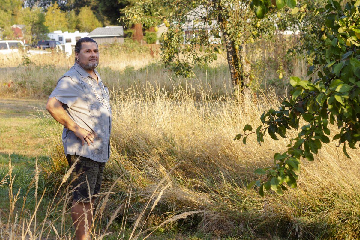 Joe Scott, a Siletz tribal member and educator on prescribed burns, stands next to a segment of his lawn he plans to burn when conditions are right. According to Scott, people oftentimes equate fire with damage, but that isn&#8217;t always the case. &#8220;If your house burns up, it&#8217;s easy to forget that you cooked food in there. You have a good relationship with fire until it takes something seriously cherished by you away,&#8221; Scott says.