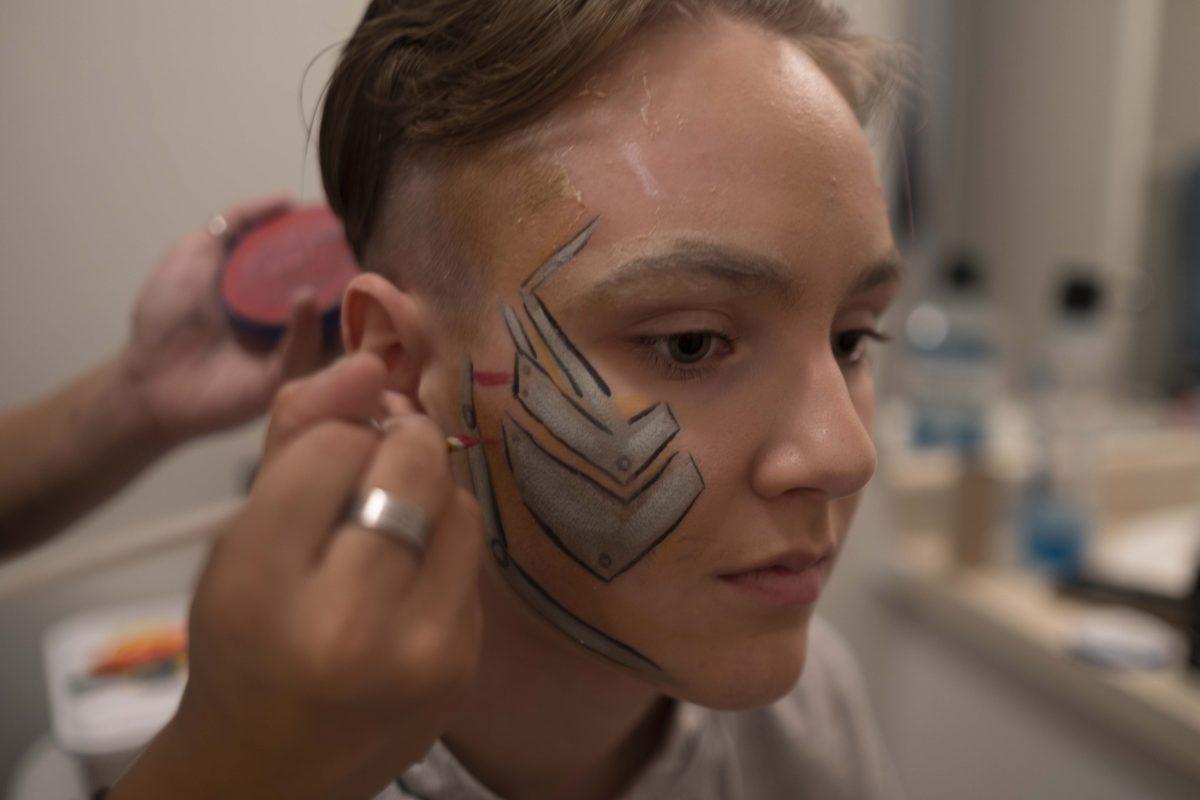 Kira Maddox paints Bleich&#8217;s face the afternoon of her performance as a cyborg in &#8220;Dragageddon.&#8221; Maddox and Bleich have been partners for three years, and Maddox does her best to help prepare for every show.