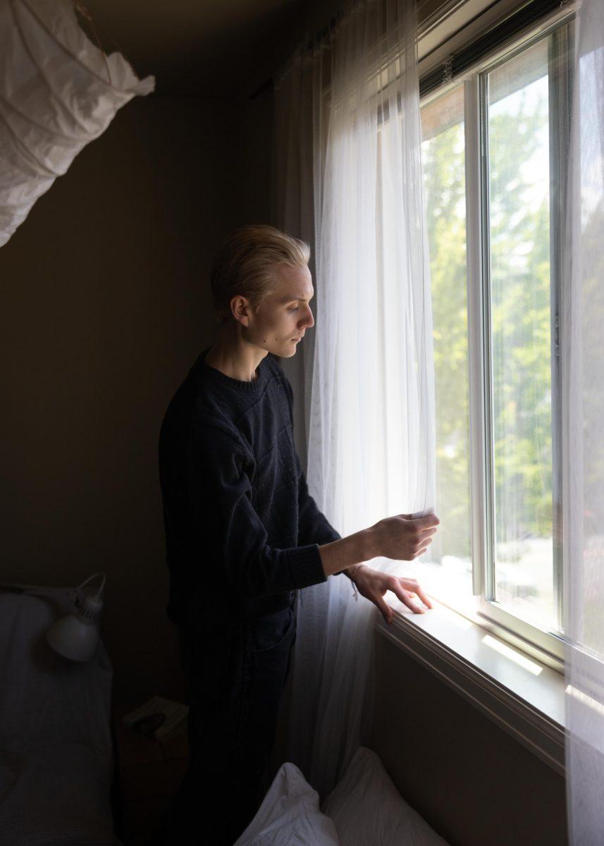 Vlad Bilan, a third-year University of Oregon Student who immigrated to the U.S. from Dnipro, Ukraine, when he was a child, looks out of the window of his apartment. &#8220;I had this dilemma where, for the first week when the Ukraine news started coming out, I was checking the news like every single day. After a while, I just kind of cut off checking the news nearly as frequently and then talked to my parents most of the time,&#8221; Bilan says.