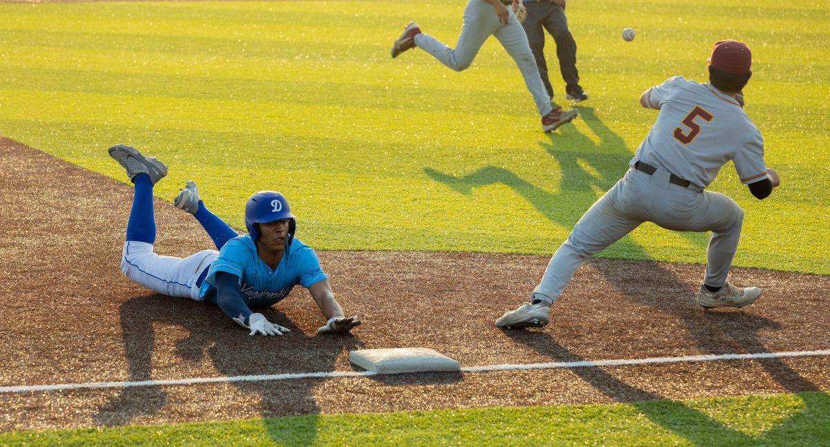 Isaiah Thomas slides into a play at third base after a hit to the opposite side of the field by a teammate put Thomas in position to score.