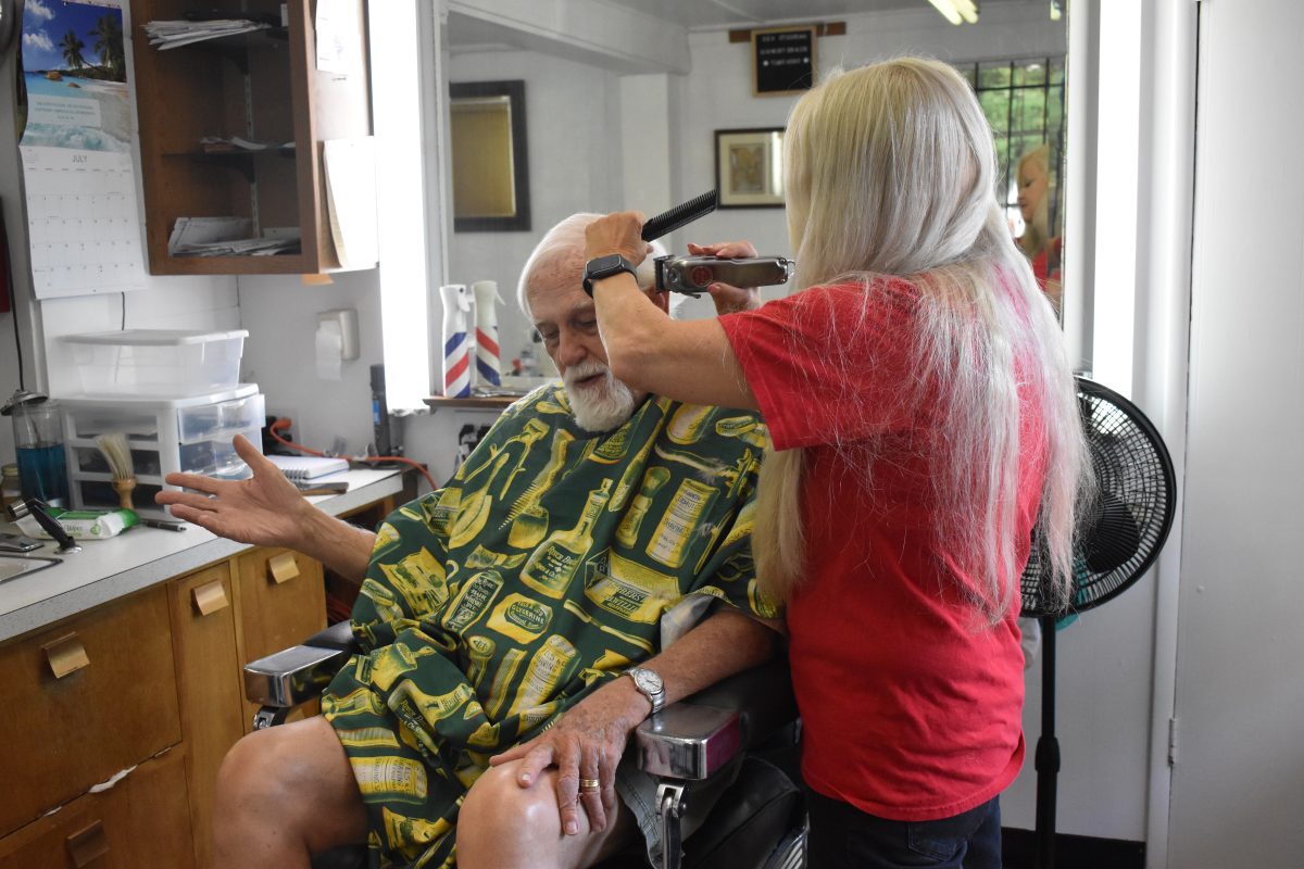 Jolan Hill chats with a customer as she cuts his hair. She began working with Shields at the beginning of the pandemic, after Shields lost a lot of her previous workers.