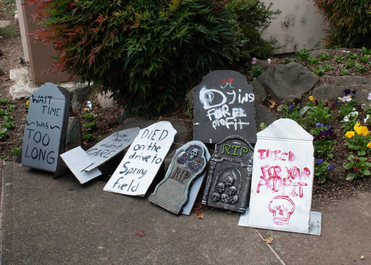 Protest signs made to look like tombstones lay on the ground as protestors gathered.